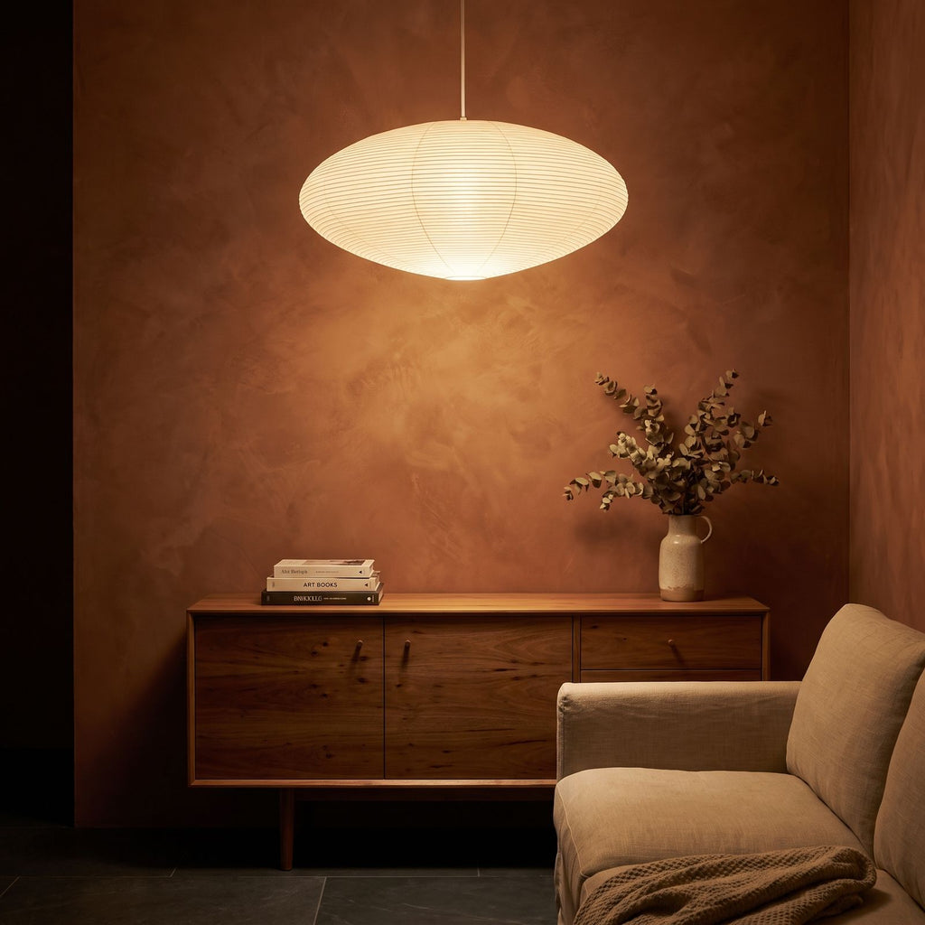Faceted Mulberry Paper Pendant Light glowing against a plaster wall at night