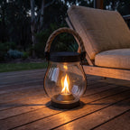 Flame effect jar solar lantern on a timber deck at night