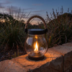 Flame effect jar solar lantern on a sandstone garden wall