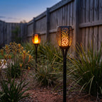 Flame Effect Openwork Torch Solar Garden Light in a garden bed at dusk