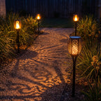 Flame effect solar garden torch along a gravel garden path at night