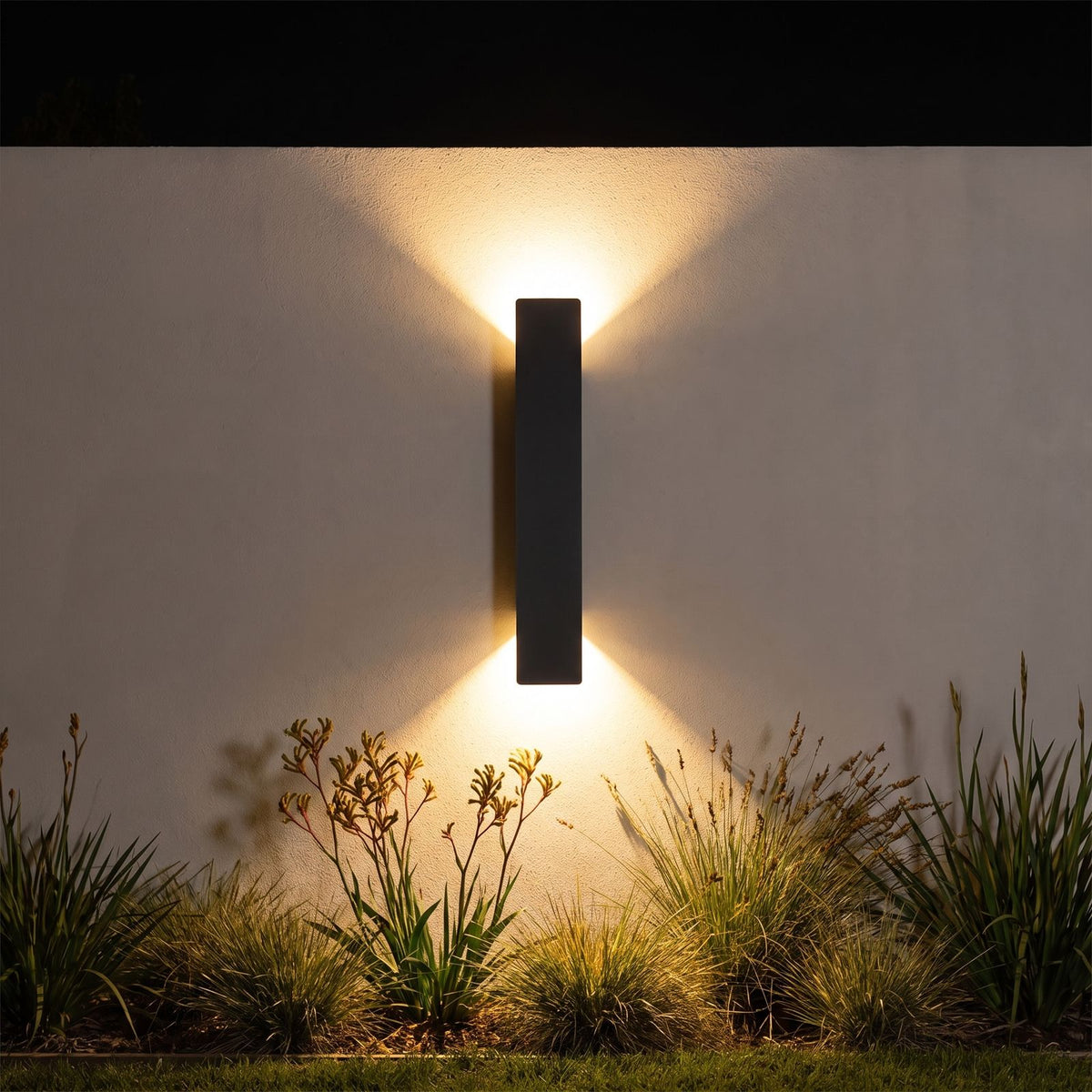 Flat bar up down outdoor wall light on a garden wall at night