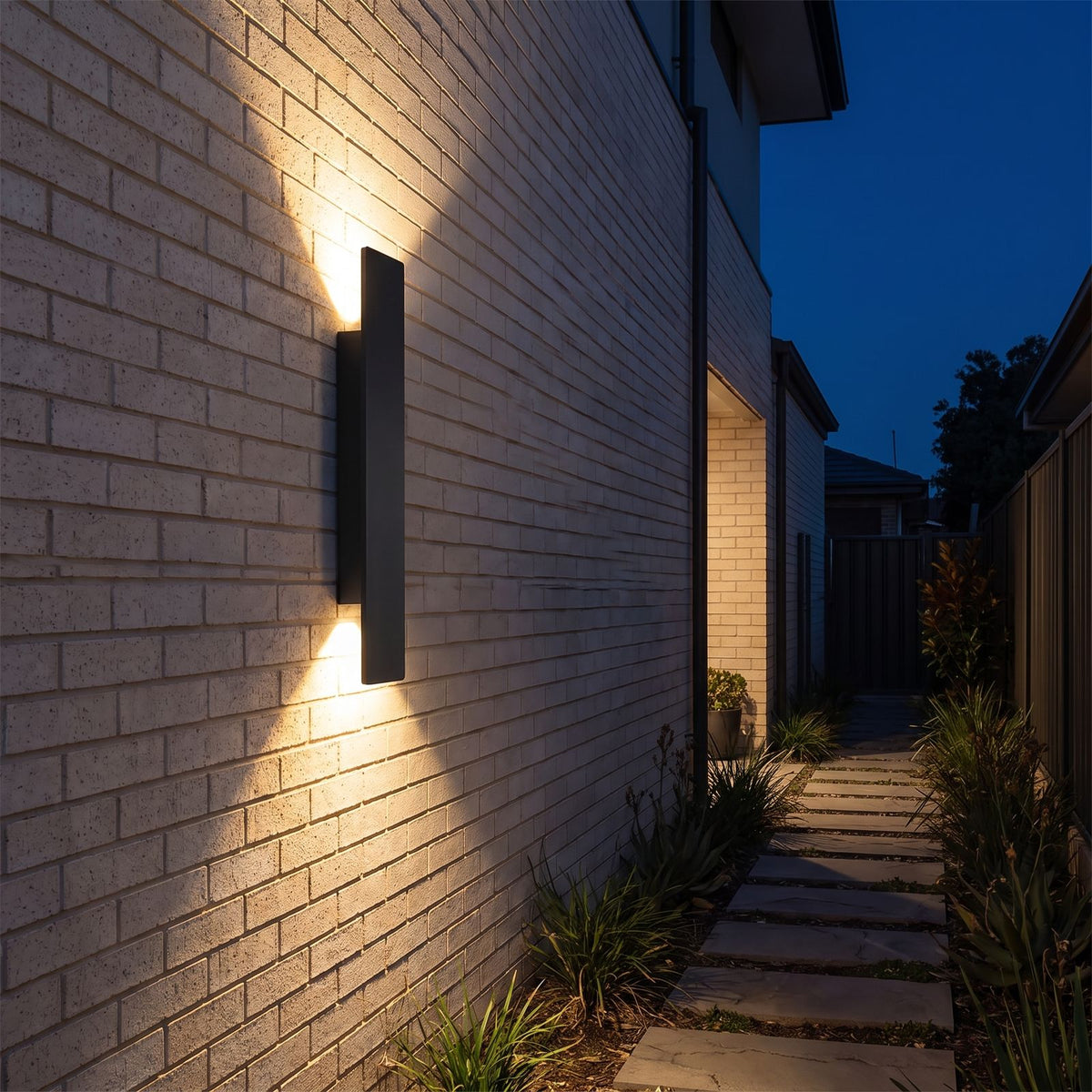 Flat bar up down outdoor wall light along a side passage at night