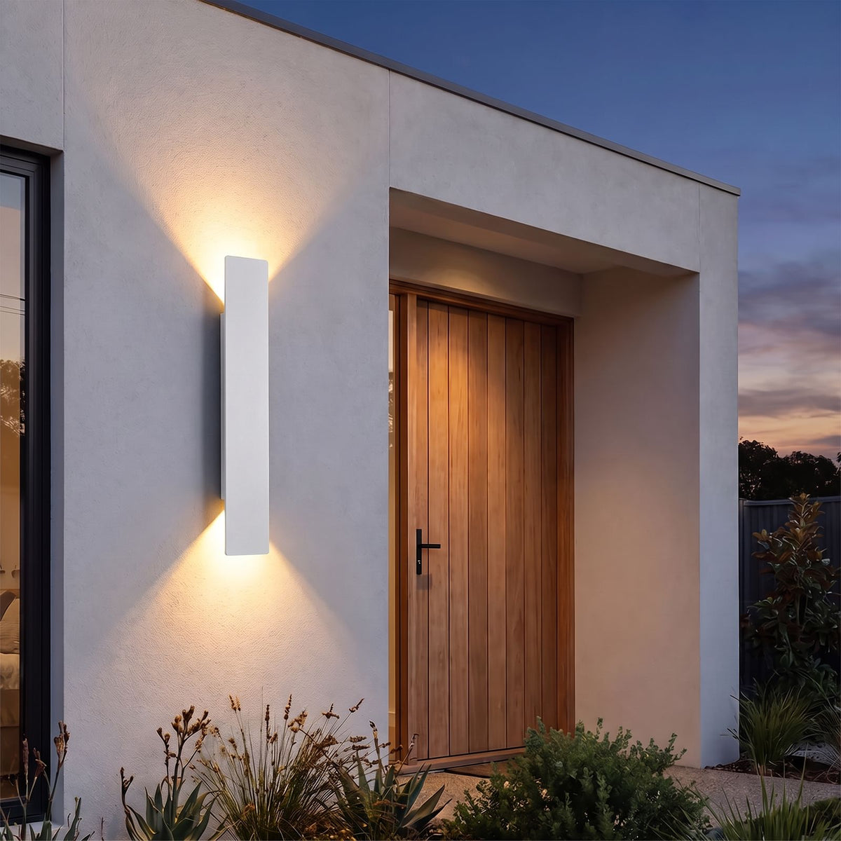 Flat Bar Aluminium Up Down Outdoor Wall Light in white beside a timber front door at dusk