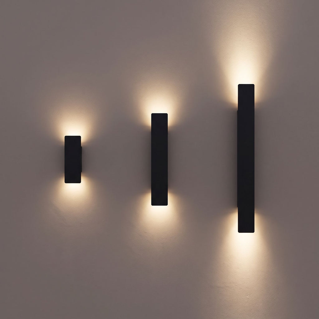 Flat Bar Aluminium Up Down Outdoor Wall Lights in black in the three lengths, 20.5, 41 and 61 cm, side by side on a rendered wall