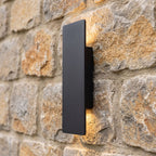 Flat Bar Aluminium Up Down Outdoor Wall Light in black on a natural stone wall, side view of its slim profile