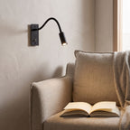 Flexible gooseneck reading wall light above an armchair in a reading corner