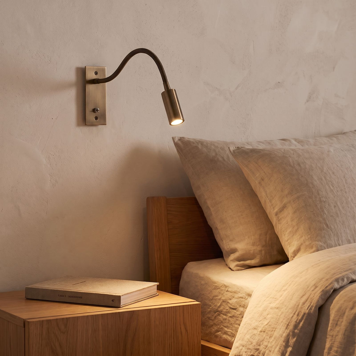 Flexible Gooseneck LED Bedside Reading Wall Light in brushed bronze beside a bed