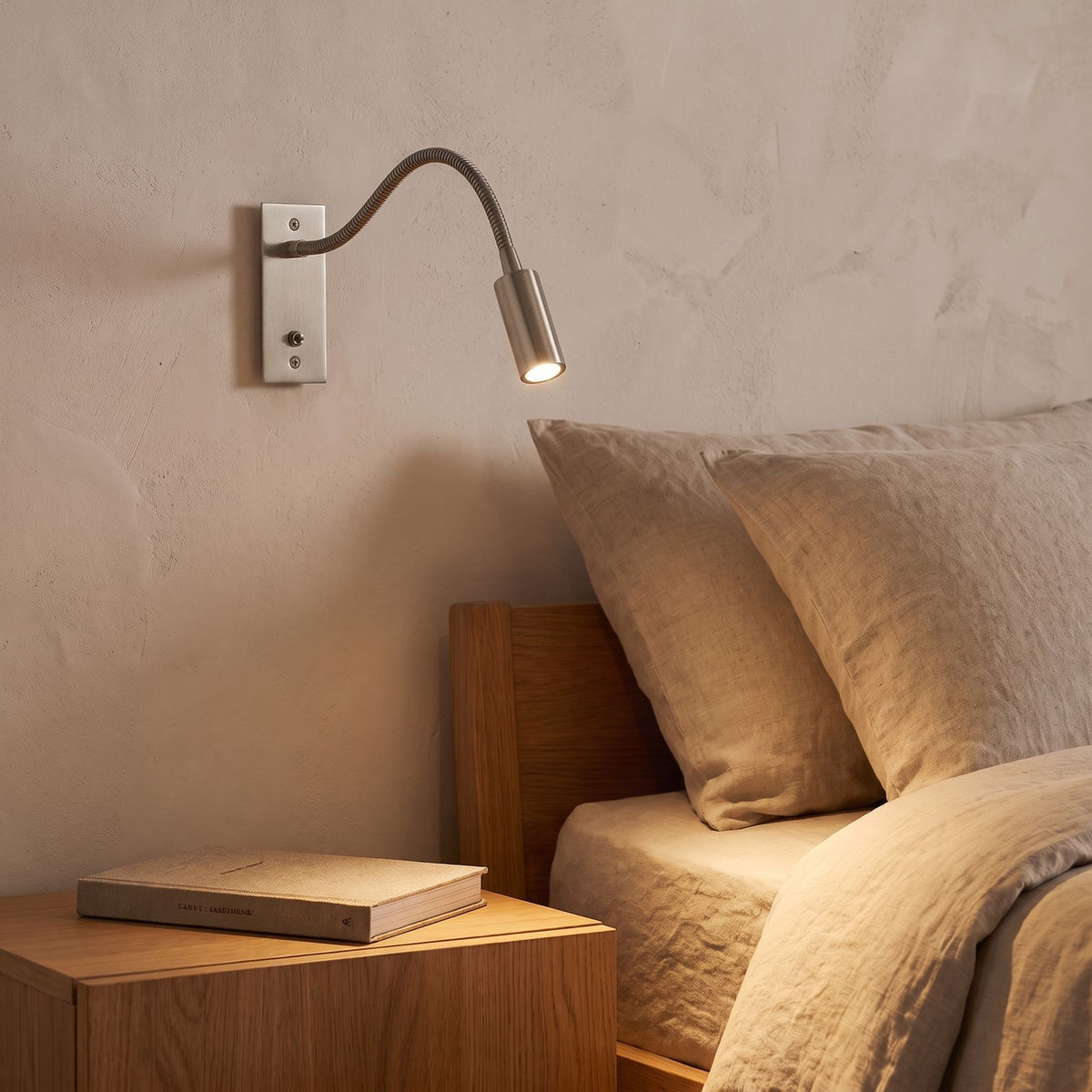 Flexible Gooseneck LED Bedside Reading Wall Light in sand nickel beside a bed