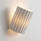 Fluted Resin Wall Light, close view at 45 degrees on a plaster wall