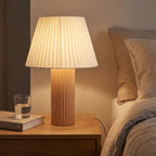 Fluted Wood Column Pleated Shade Table Lamp on a bedside table