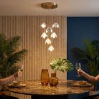 Ceramic Petal Cluster Pendant Light in warm white above a round marble dining table at a dinner party