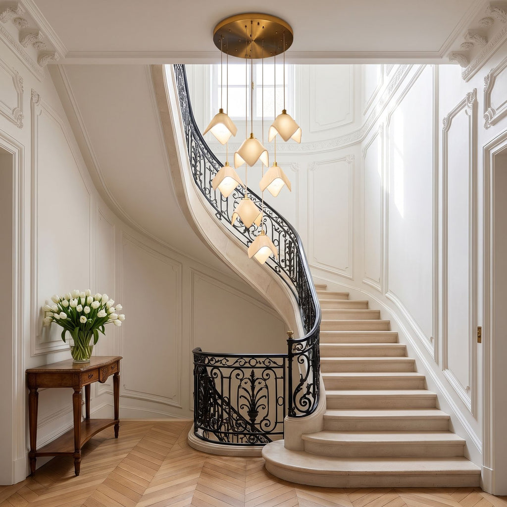 Ceramic Petal Cluster Pendant Light hanging into a curved stone staircase with a wrought-iron balustrade