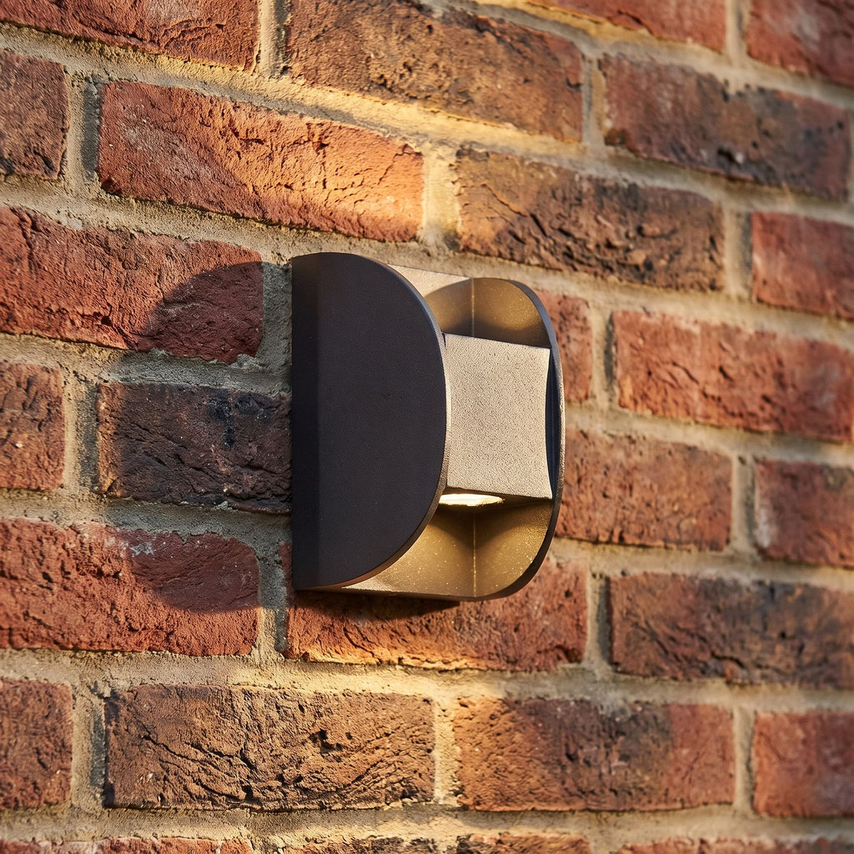 Forged Metal Mini Up Down Outdoor Wall Light, close view at 45 degrees on a stone wall