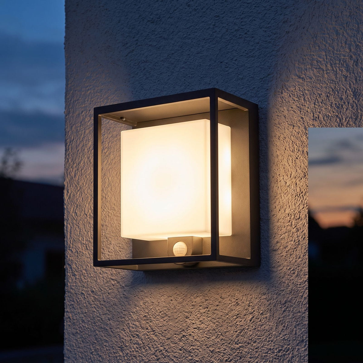 Framed Acrylic Solar Sensor Outdoor Wall Light on a porch wall at dusk