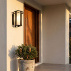 Frosted Glass Prairie Outdoor Wall Lantern beside a timber front door