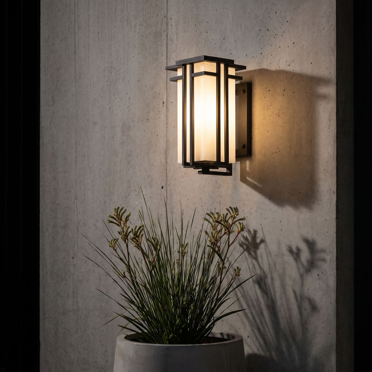 Frosted Glass Prairie Outdoor Wall Lantern on a concrete wall at night