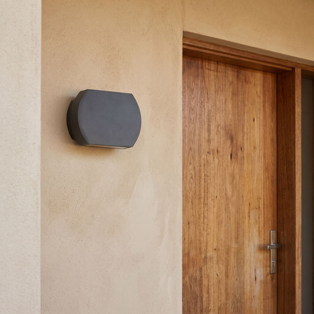 Geometric Glass Up Down Outdoor Wall Light beside a timber front door