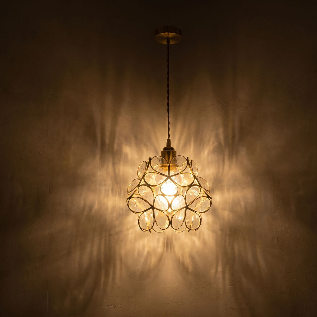Glass Blossom Cluster Pendant Light glowing against a plaster wall at night