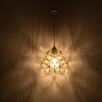 Glass Blossom Cluster Pendant Light glowing against a plaster wall at night
