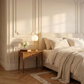 Glass Globe Gold Stem Bedside Table Lamp on a bedside table in a bedroom