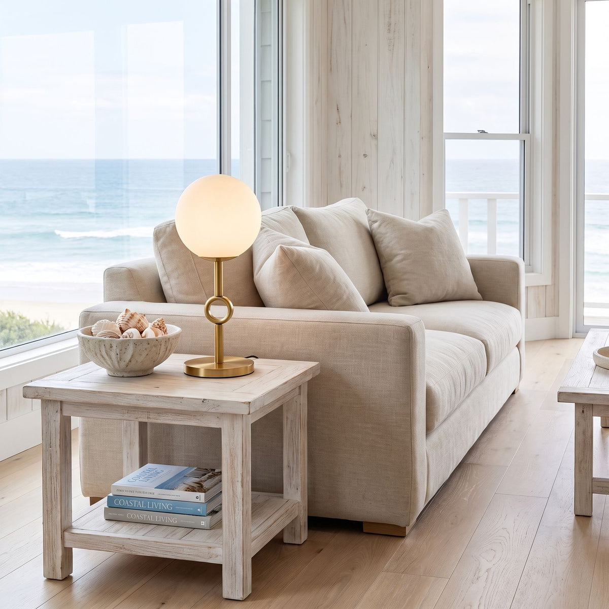 Glass Globe Gold Stem Bedside Table Lamp on a side table beside a sofa in a living room