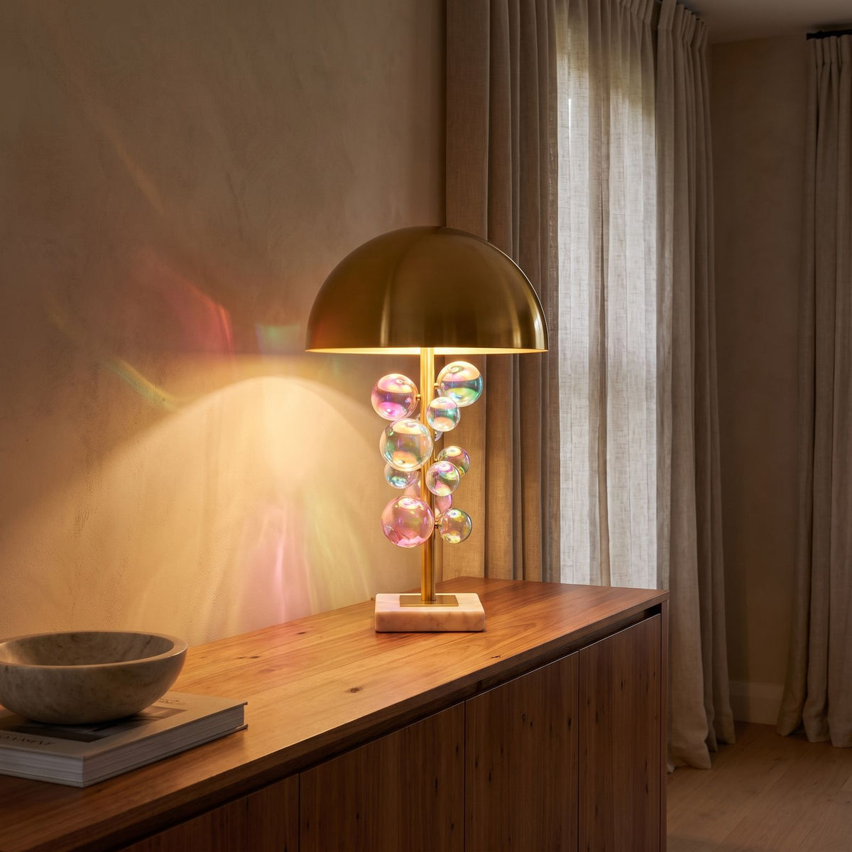 Glass Orb Cluster Marble Table Lamp glowing on a timber console at dusk