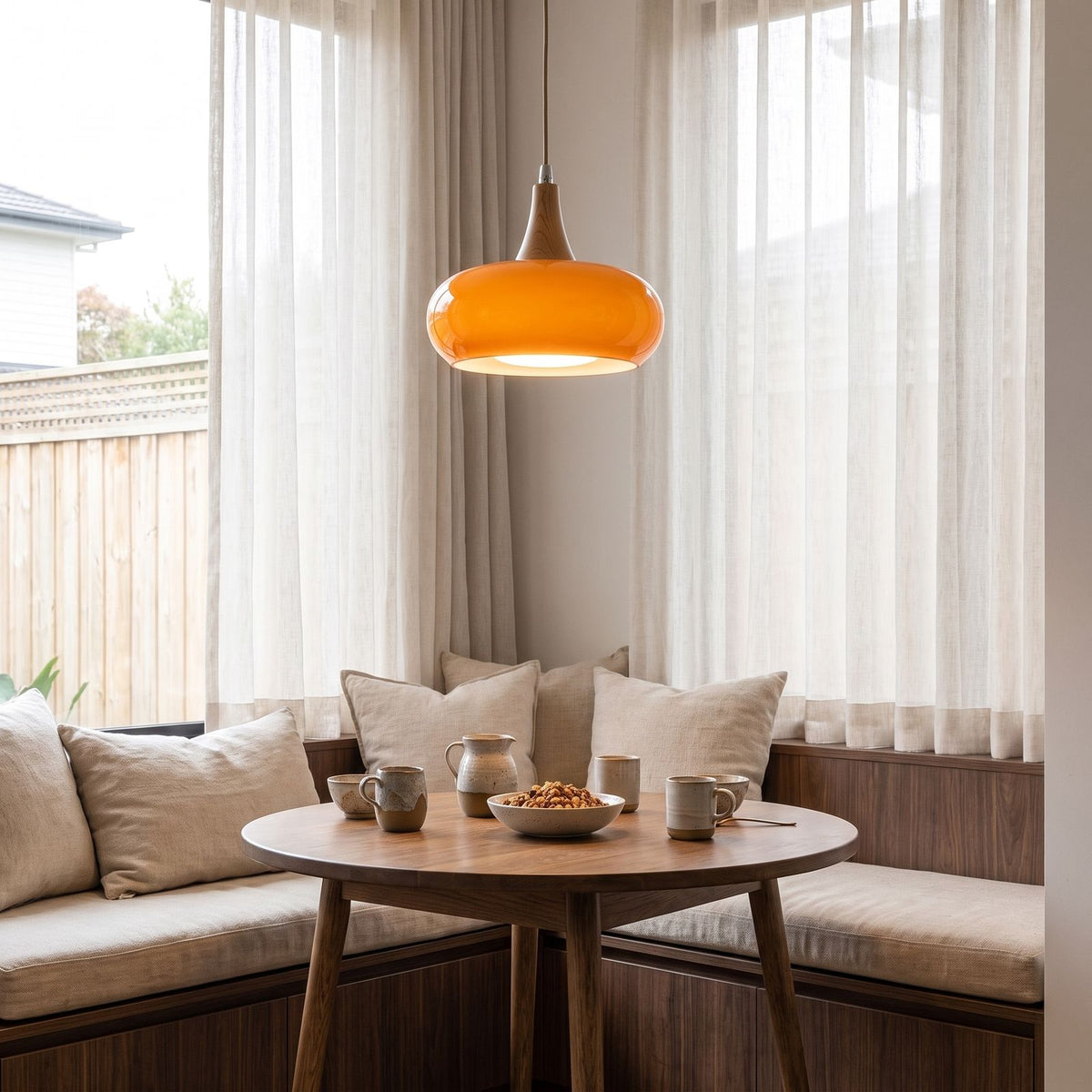 Glass saucer and timber pendant light over a breakfast nook table