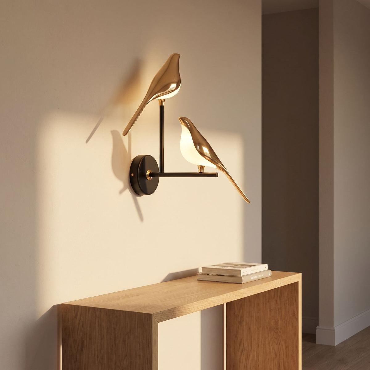 Gold bird sculpture LED wall light on a hallway wall with two birds, wide view