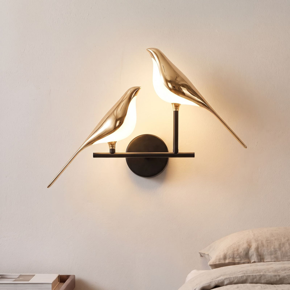 Gold Bird Sculpture LED Wall Light with two birds beside a bed