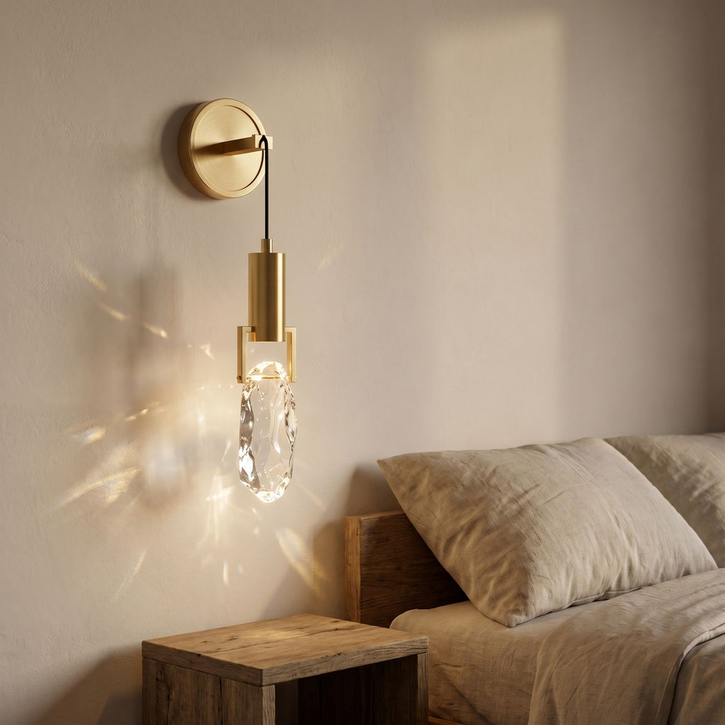 Gold Hook Hanging Glass Rock LED Wall Light beside a bed