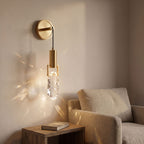 Gold hook hanging glass rock wall light above an armchair in a reading corner