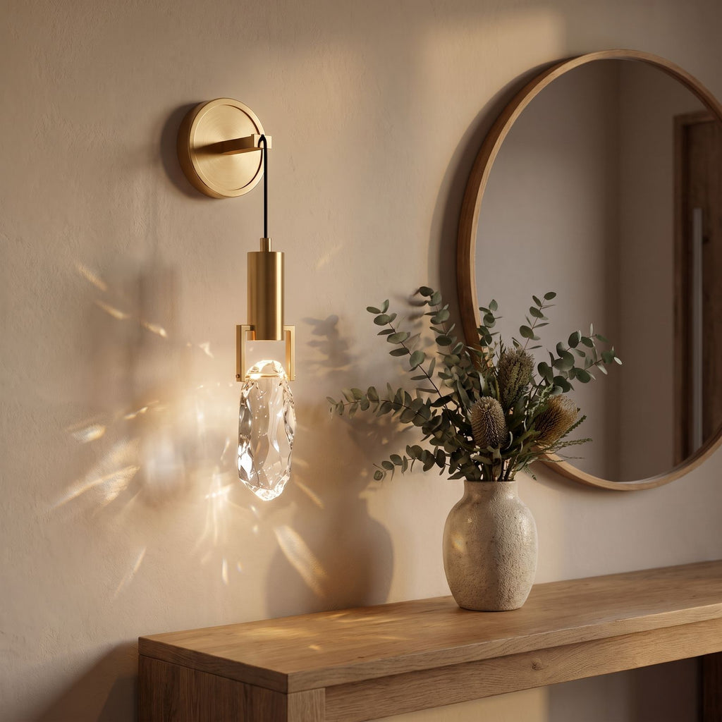 Gold hook hanging glass rock wall light beside a round mirror in an entry hall