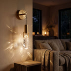 Gold hook hanging glass rock wall light beside a living room sofa at night