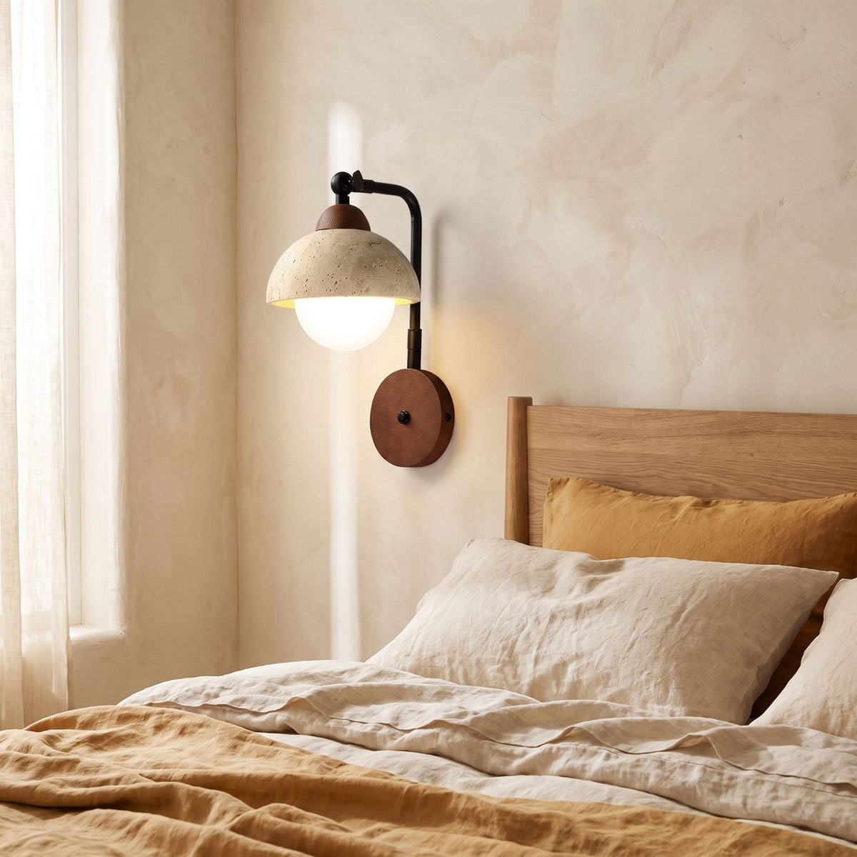 Gooseneck Travertine Dome and Globe Wall Light on a bedroom wall beside the bed