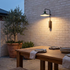 Green Cone Shade Outdoor Wall Light above an outdoor dining table