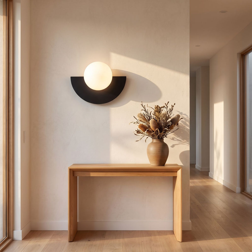 Half moon iron and opal globe wall light on a hallway wall, wide view