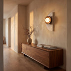 Half Moon Travertine and Wood Wall Light in a hallway above a timber console