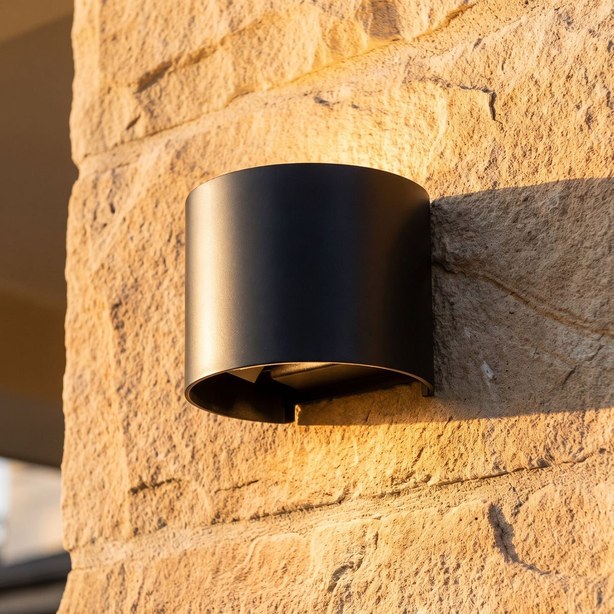 Half Round Up Down Outdoor Wall Light, close view at 45 degrees on a stone wall