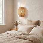 Hand Woven Natural Fibre Up Down Wall Light on a bedroom wall beside the bed