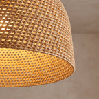 Close view of the handwoven rattan rope weave with the light glowing through