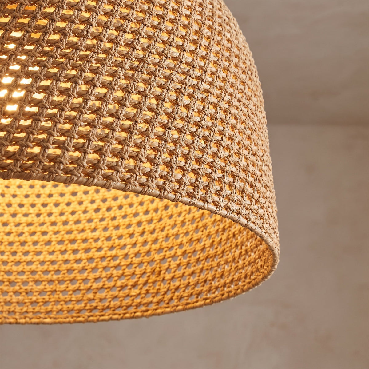 Close view of the handwoven rattan rope weave with the light glowing through