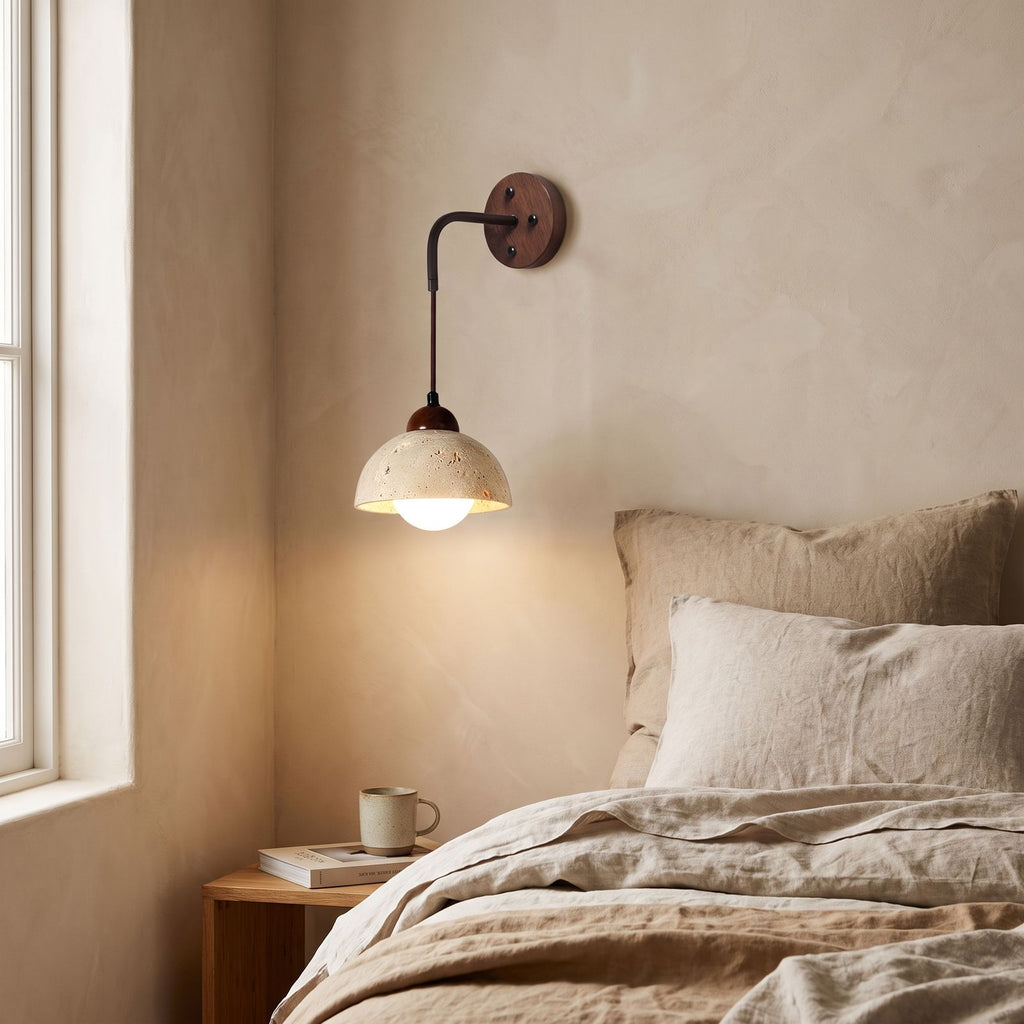 Hanging Travertine Shade LED Wall Light on a bedroom wall beside the bed