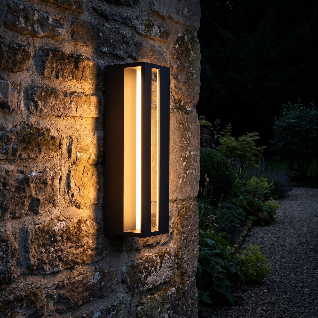 Hollow Rectangle Acrylic Outdoor Wall Light glowing on a garden wall at night