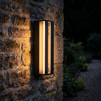 Hollow Rectangle Acrylic Outdoor Wall Light glowing on a garden wall at night