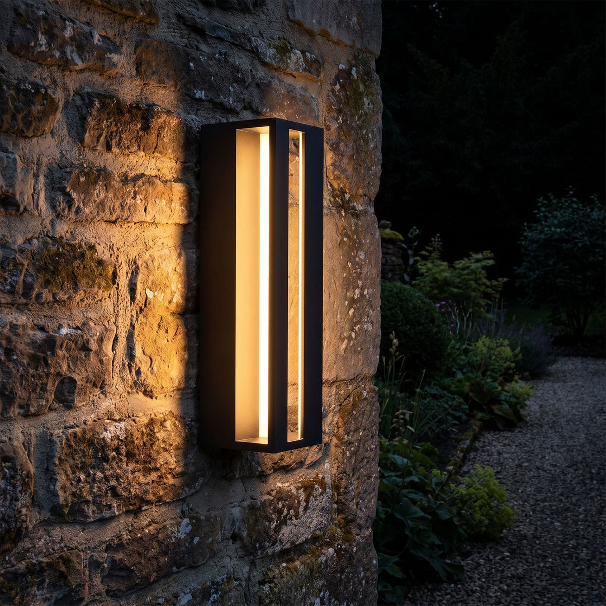 Hollow Rectangle Acrylic Outdoor Wall Light glowing on a garden wall at night