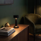 Black Hourglass cordless table lamp on a sideboard in a dark green living room