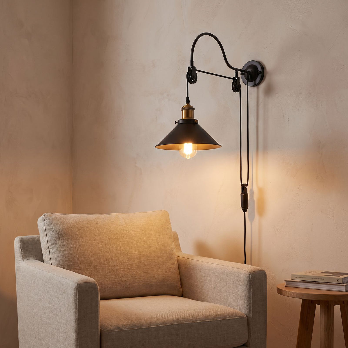 Industrial pulley wall light above an armchair in a reading corner