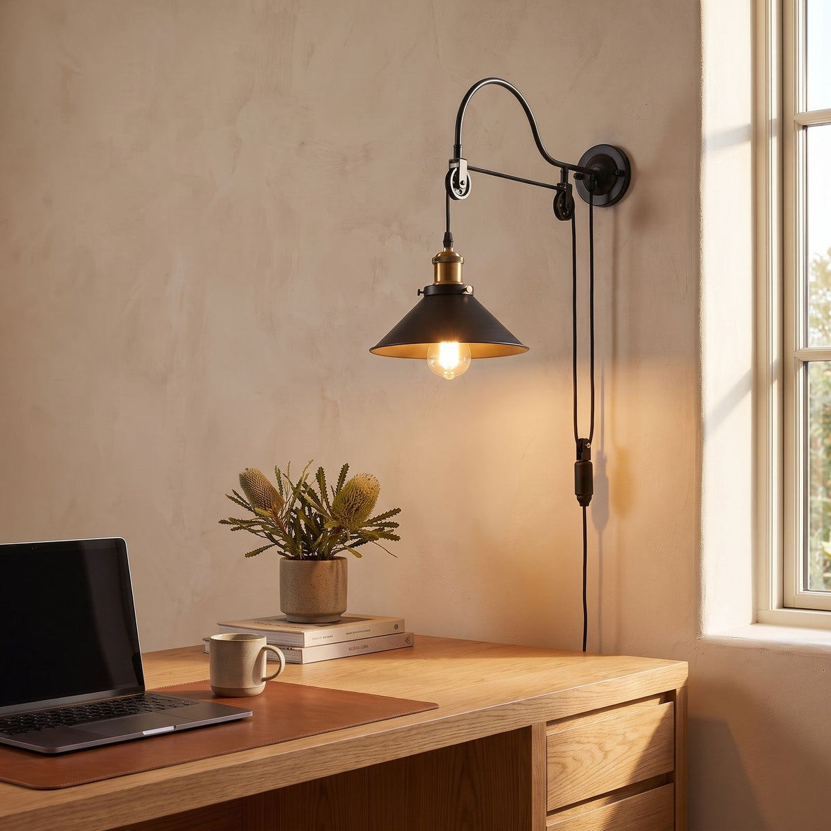 Industrial pulley wall light above a home office desk