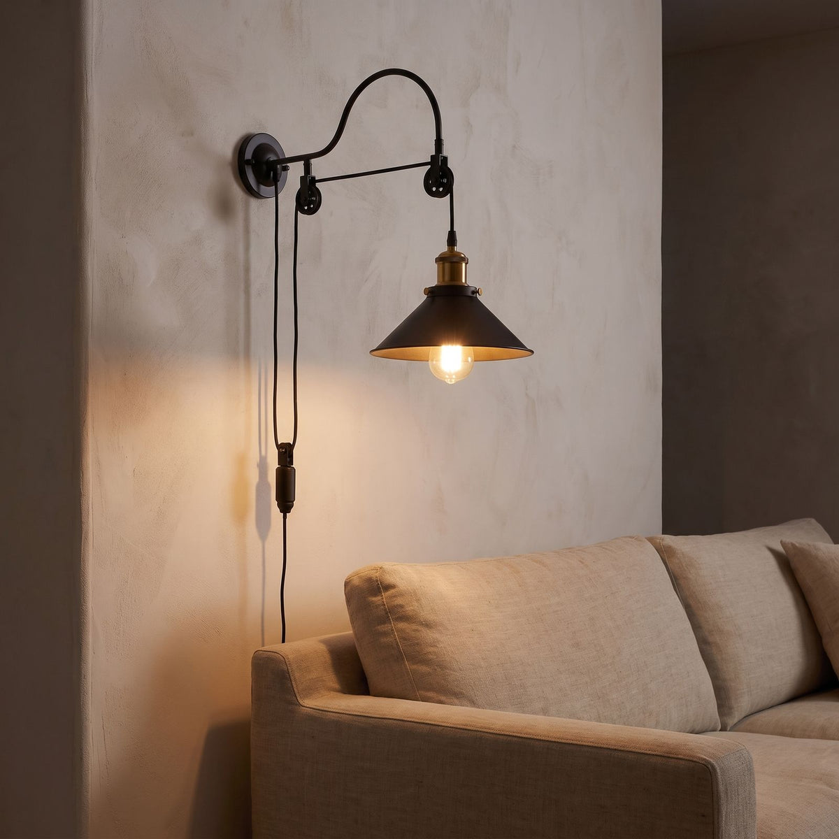 Industrial pulley wall light beside a living room sofa at night